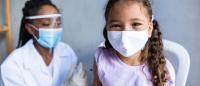 Covid-19 Vaccine - Young child in mask being vaccinated by doctor in mask